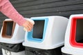 A female`s hand throwing an empty cup of coffee into the trash can. close-up image Royalty Free Stock Photo