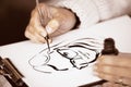 Female's hands drawing a caricature with black ink Royalty Free Stock Photo