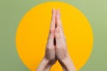 Female`s hands in the gesture of thanksgiving and prayer. Close up. Green background with a yellow circle Royalty Free Stock Photo