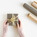 Female`s hands holding a Christmas present box wrapped in kraft paper Royalty Free Stock Photo