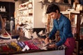 Female Sales Assistant Arranging Textiles In Homeware Store