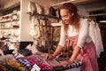 Female Sales Assistant Arranging Textiles In Homeware Store