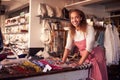 Female Sales Assistant Arranging Textiles In Homeware Store