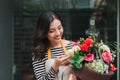 Female sales assistant working as florist and holding bouquet