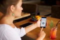 Female scanning fingerprint on her smartphone with program script on laptop display on backround. Woman unlock mobile Royalty Free Stock Photo