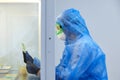 Female science researcher in protective uniform and equipment works with petri dish in laboratory Royalty Free Stock Photo