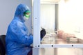 Female science researcher in protective uniform and equipment works with petri dish in laboratory Royalty Free Stock Photo