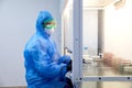 Female science researcher in protective uniform and equipment works with petri dish in laboratory Royalty Free Stock Photo