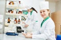 Female scientific pharmacy worker preparing medicine drug