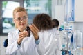 Female Scientific Researcher In Laboratory Doing Research, Woman Working With Chemicals Over Group Of Scientist