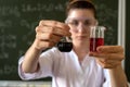 female scientist doing scientific tests with chemical flask and liquid in school laboratory Royalty Free Stock Photo