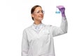 Female scientist in goggles with chemical in flask