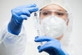 Female scientist holding syringe and vaccine vial ampoule