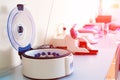 Female scientist loads some vials of liquid into a centrifuge in a laboratory Royalty Free Stock Photo