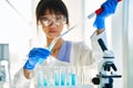 Female scientist making microbiology research using pipette, flask and test tubes working in modern chemical lab Royalty Free Stock Photo