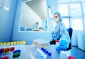 Female scientist in a protective medical mask and rubber gloves makes PCR DNA tests in a modern chemical and Royalty Free Stock Photo