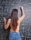 Female Scientist Solving Complex Equations on Chalkboard: Advanced Mathematics and Physics