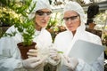 Female scientists in clean suit examining plants Royalty Free Stock Photo