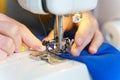 Female seamstress sewing or stitching fabric with professional machine