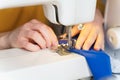 Female seamstress sewing or stitching fabric with professional machine