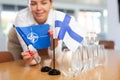 Female secretary places flags of the NATO (OTAN) and Finland on table before the negotiations of top political