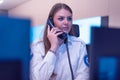 Female security guard operator talking on the phone, calling in the alarming event to the external team of field force agents Royalty Free Stock Photo