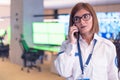 Female security guard operator talking on the phone, calling in the alarming event to the external team of field force agents Royalty Free Stock Photo