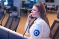 Female security guard operator talking on the phone, calling in the alarming event to the external team of field force agents Royalty Free Stock Photo