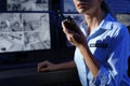 Female security guard with portable transmitter at workplace, closeup. Royalty Free Stock Photo