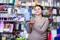 Female seller demonstrating perfume bottles in cosmetics shop