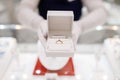 Female seller hands holds gold diamond ring in box