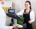 Female seller helping customer to weigh cabbage