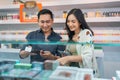 female seller holding the digital tablet while observing the vape mods