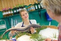 Female seller holding fish in front client