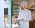 female seller in white robe offering sweets in local confectionery Royalty Free Stock Photo