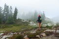 Female Senior Hiker on Trail With Walking Poles.