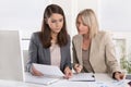 Female senior and junior managers sitting at desk working together in a business team. Royalty Free Stock Photo