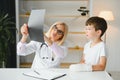 Female senior pediatrician showing x-ray of wrist and hand to little boy patient. Child at doctors office