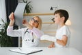 Female senior pediatrician showing x-ray of wrist and hand to little boy patient. Child at doctors office