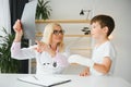 Female senior pediatrician showing x-ray of wrist and hand to little boy patient. Child at doctors office