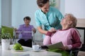 Senior residents in living room of nursing facility with supporting nurse