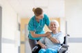 Senior woman in wheelchair with nurse in hospital