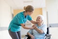 Senior woman in wheelchair with nurse in hospital