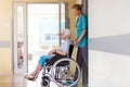 Senior woman in wheelchair with nurse in hospital