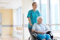 Senior woman in wheelchair with nurse in hospital