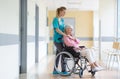 Senior woman in wheelchair with nurse in hospital