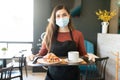 Female Server With Order In Tray At Cafe