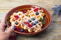 Female serving homemade waffles fresh berry fruit