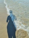 female shadow on beach. golden sand and blue waves of sea. summer vacation and beach holiday concept. soft focus Royalty Free Stock Photo