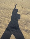 female shadow on yellow river sand